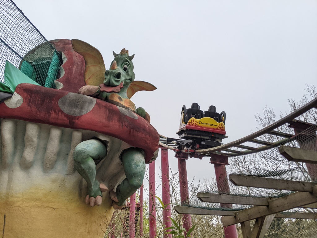 A train on Dragon's Fury passing one of the theming items in Dragon's play area at Chessington