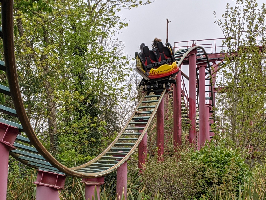 A train racing along the track of Dragon's Fury at Chessington