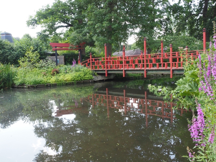 An Oriental style bridge goes over a small lake